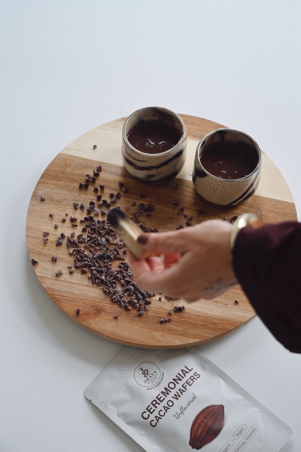 IMAYA cacao wafers met cacao nibs op een houten plank